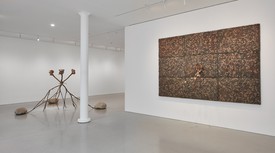 Installation view of Giuseppe Penone’s exhibition at Gagosien, San Francisco. A bronze sculpture and a wall-mounted sculpture including leaves.