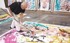Georg Baselitz working on a painting in his studio.