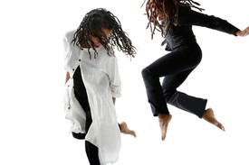 Bebe Miller and Cynthia Oliver in motion dancing, mid-jump, against a white background