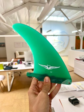 Hand holding a green surfboard fin