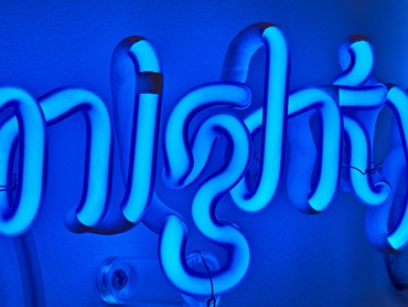 Blue neon lettering spelling M I G H T Y